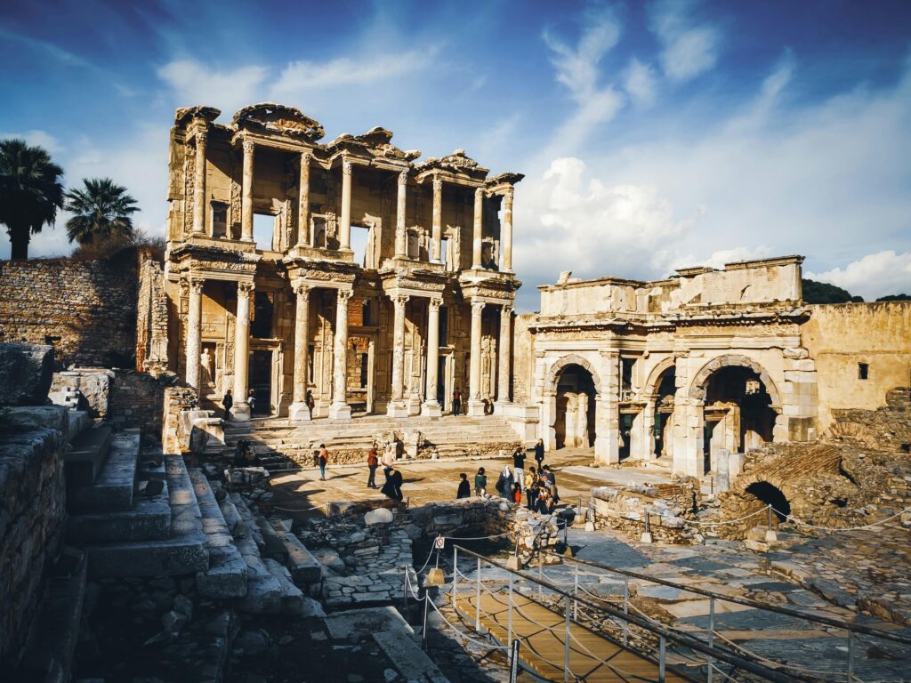 Explore the ancient ruins of the Library of Celsus under a clear blue sky in Ephesus, Turkey.
