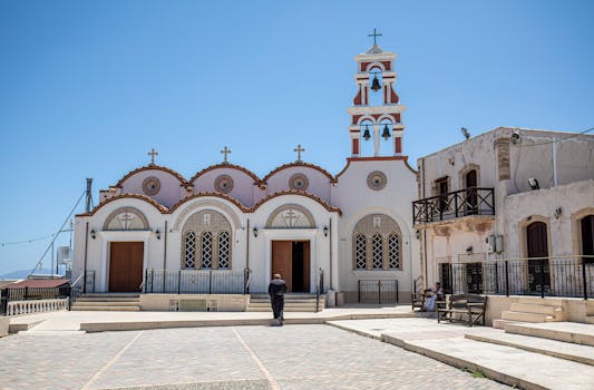 A picturesque view of a traditional Greek church in Hersonissos, Crete, under a clear blue sky.